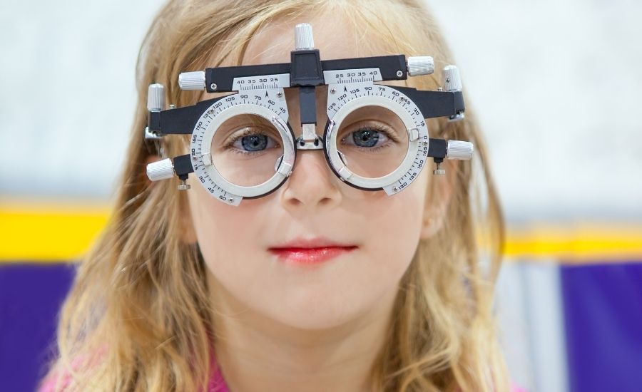 Michigan Contact Lens | Best Myopia Control in Detroit | #1 Clinic for Kids & Adults A young girl undergoing a comprehensive eye exam in a trial frame, the first step in our myopia control in Detroit program.