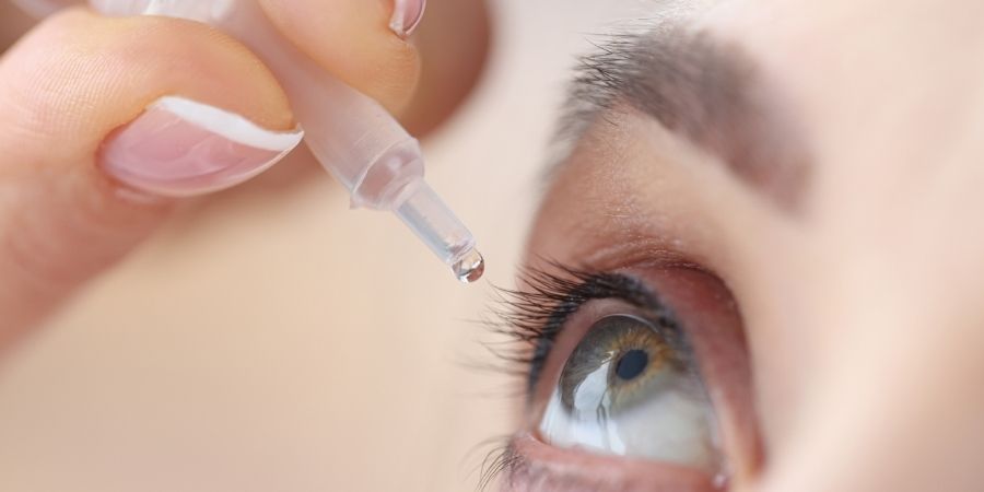 Michigan Contact Lens | Contacts for Irregular Cornea: Best 3 Solutions Revealed A person applying lubricating eye drops, a common first step before getting contacts for irregular cornea.