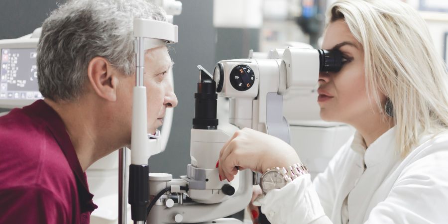 Michigan Contact Lens | 6-Step Scleral Lens Fitting in Birmingham MI: Your Guide An optometrist performing a detailed eye exam, the first step in a scleral lens fitting in Birmingham MI.