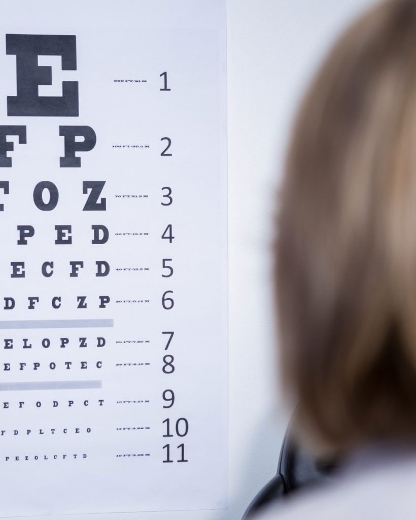 optometrist-looking-at-eye-chart